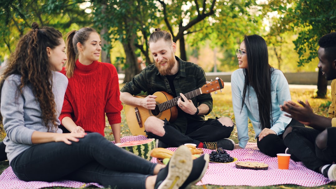 Friends enjoying a picnic and music in the park